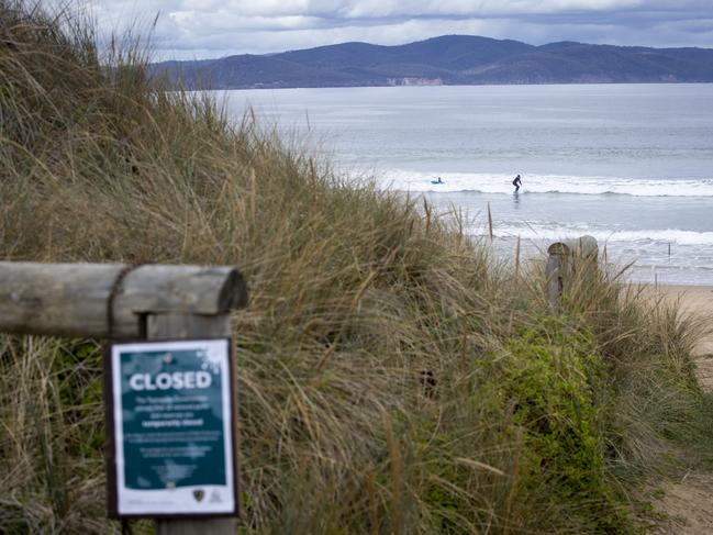 People surfing at Clifton Beach although it being signed very well that Parks and Wildlife has closed the beach due to COVID-19. Picture: LUKE BOWDEN