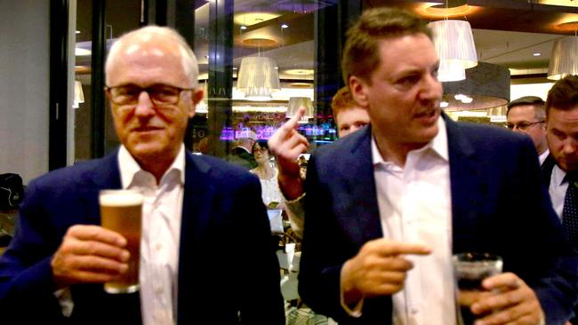 Malcolm Turnbull  the Prime minister with a person giving the finger between the PM and Ross Vasta MP, meeting the locals at the Carindale Hotel, Carindale , Brisbane, on Thursday May 17, 2018. Politics in the Pub Westfield Shopping Centre. (AAP Image/Steve Pohlner)