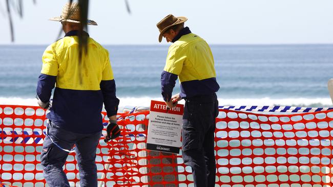 Gold Coast council workers remove the barricades at Surfer Paradise, opening the beaches after the coronavirus caused closure of beaches. Picture: Tertius Pickard