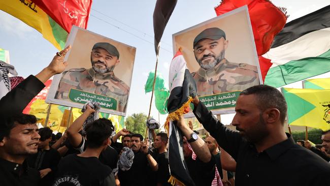 Iraqis attend the funeral of a military commander from Iraq’s Hezbollah Brigades in Baghdad.