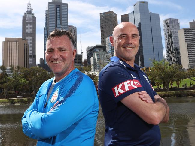 Melbourne City coach Warren Joyce (left) and Melbourne Victory coach Kevin Muscat pose for a photograph during a press conference prior to the Melbourne A-League derby in Melbourne, Friday, October 19, 2018. Melbourne Victory and Melbourne City face off in Round One of the Hyundai A-League on Saturday night at Marvel Stadium. (AAP Image/David Crosling) NO ARCHIVING