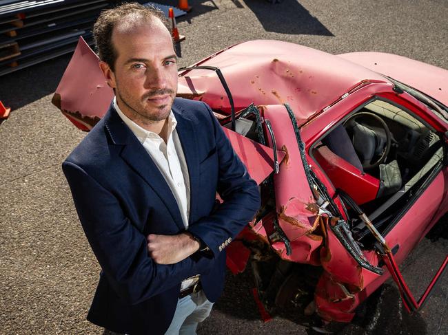 Advertiser journalist Ben Hyde with the mangled wreck of the Mitsubishi Lancer he was driving when seriously injured in a car crash on West Tce, Adelaide, on October 4, 2021, pictured on July 3rd, 2024, at Ottoway.Picture: Tom Huntley