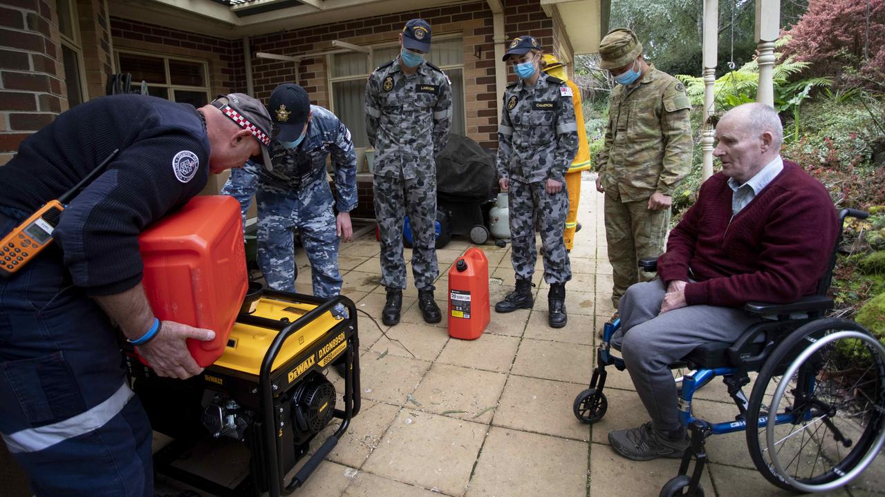 CFA volunteers and Australian Defence Force personnel deliver a generator to an Olinda resident. Picture: Arsineh Houspian