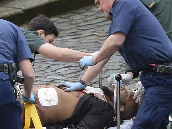 A man, suspected to be the alleged attacker, is treated by emergency services. Picture: AP