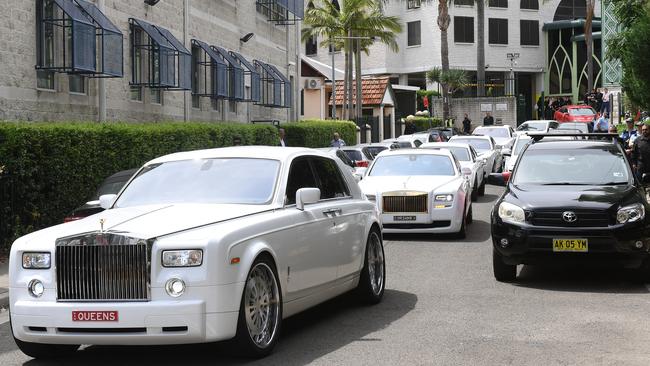 A procession of Rolls Royces and Bentleys follow the hearse carrying the coffin of Hawi after his funeral.