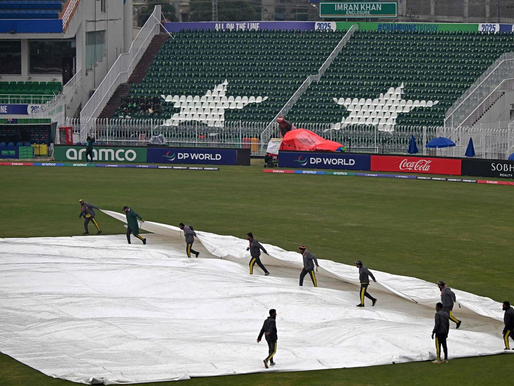 Groundmen cover the pitch as it rains before the start of the ICC Champions Trophy one-day international (ODI) cricket match between Australia and South Africa at the Rawalpindi Cricket Stadium. Picture: AFP