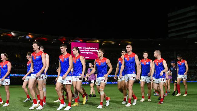 The Dees walk off the field in the dark. (Photo by Albert Perez/AFL Photos via Getty Images)