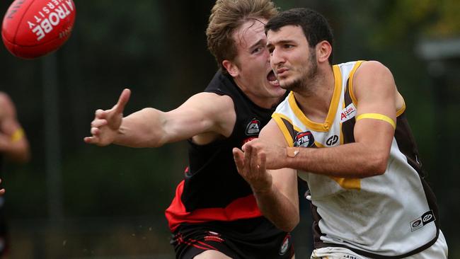 NFL: Thomastown’s Daniel Caruso gets a handball away under pressure from David Evans of Eltham. Picture: Hamish Blair