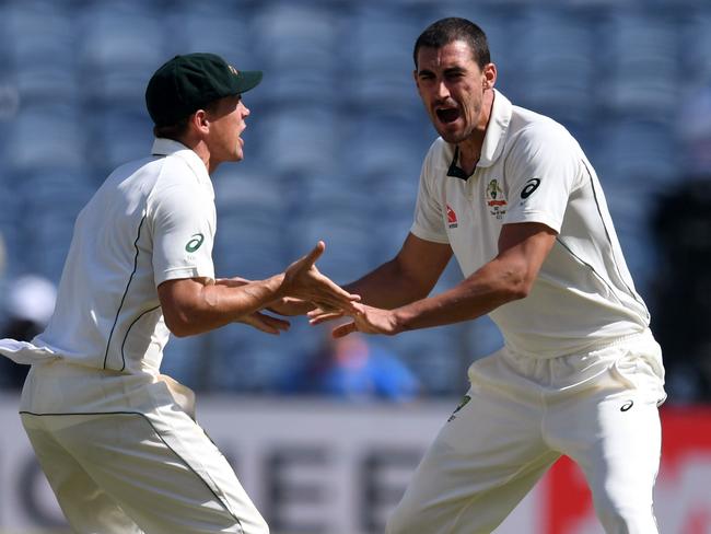 Australia's Mitchell Starc (R) celebrates with teammate Steve O'Keefe after the dismissal of India's captain Virat Kohli.