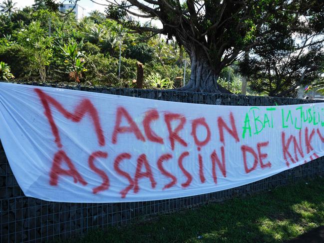 This picture shows banners set up along a road following a visit by French President Emmanuel Macron in Noumea. Picture: AFP