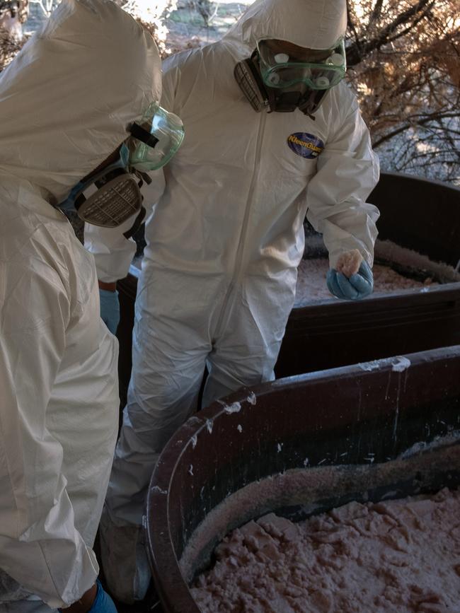 Mexican Army experts examine containers of crystal meth paste at a clandestine laboratory near La Rumorosa town in Tecate, Baja California state. Picture: AFP