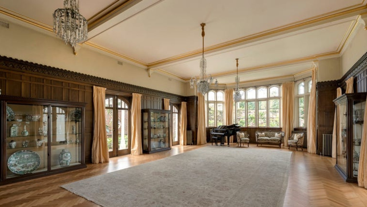 The ballroom features a fireplace, parquetry floors, timber panelling and bay windows.