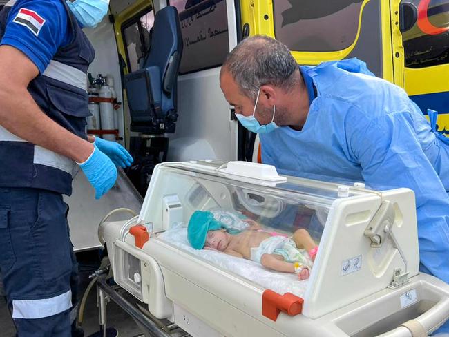 Egyptian medics wheel a premature Palestinian baby evacuated from Gaza to an ambulance on the Egyptian side of the Rafah border crossing with the Gaza Strip. Picture: AFP