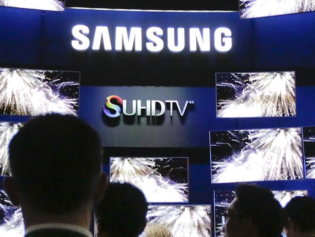 Attendees gather outside the Samsung booth, featuring its new SUHD TV, at the International CES Tuesday, Jan. 6, 2015, in Las Vegas. (AP Photo/Jae C. Hong)