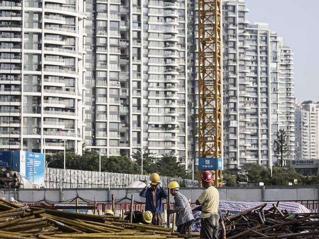 Workers in Shenzhen, China, move materials at a construction site in August. The city had the world’s largest increase in apartment prices last year, a sign of China’s housing bubble. PHOTO: QILAI SHEN/BLOOMBERG NEWS