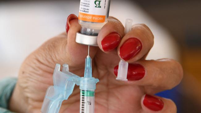 (FILES) A healthcare worker prepares a dose of the CoronaVac COVID-19 vaccine at a drive-thru vaccination post in Brasilia on September 13, 2021. Two years after Brazil began emerging from its pandemic horror show thanks to a massive immunization campaign, officials face a paradoxical predicament: vaccination rates have plunged, and not just for Covid-19, leaving millions exposed to once-eradicated diseases. (Photo by EVARISTO SA / AFP)