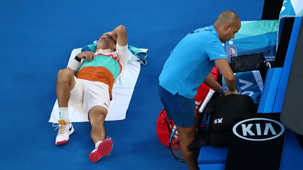 MELBOURNE, AUSTRALIA - JANUARY 23: Kei Nishikori of Japan receives treatment in his quarter final match against Novak Djokovic of Serbia during day 10 of the 2019 Australian Open at Melbourne Park on January 23, 2019 in Melbourne, Australia. (Photo by Cameron Spencer/Getty Images)