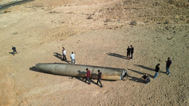 People gather around the remains of a ballistic missile following an attack by Iran on Israel near the southern city of Arad. Picture: Amir Cohen/Reuters/The Times