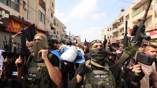 Palestinian militants carry the body of 19-year-old Ahmad Awawda who was killed in clashes with Israeli troops in the occupied West Bank region of Nablus the previous day.