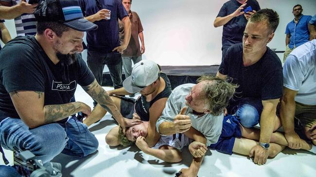 Neil Erikson (left) helps subdue a protester who threw an egg at Senator Anning. Picture: Jake Nowakowski