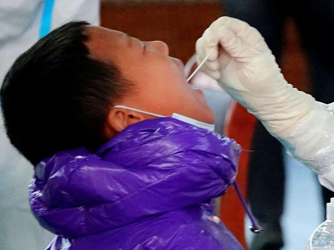 This photo taken on December 1, 2021 shows a child undergoing nucleic acid tests for the Covid-19 coronavirus in Hulun Buir, in China's Inner Mongolia Region. (Photo by AFP) / China OUT