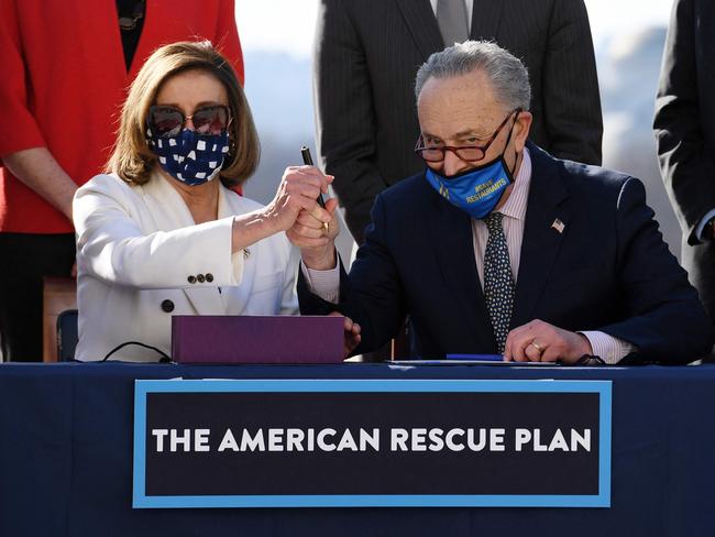 Speaker of the House Nancy Pelosi (L) and Senate Majority Leader Chuck Schumer sign the American Rescue Plan Act after the House Chamber voted on the final revised legislation of the $1.9 trillion Covid-19 relief plan, at the US Capitol on March 10, 2021 in Washington, DC. - The US Congress on Wednesday passed Joe Biden's enormous economic relief package, delivering a resounding victory for the US president and a desperately needed injection of cash to millions of families and businesses enduring the coronavirus pandemic. (Photo by OLIVIER DOULIERY / AFP)