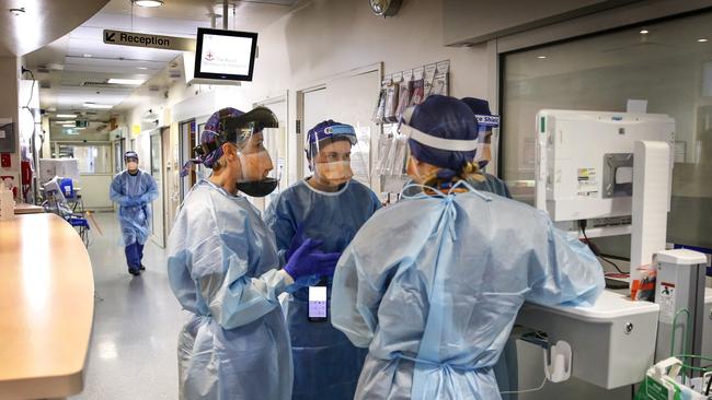 Behind the Scenes at the Royal Melbourne Hospital ICU and COVID wards. Nurses gather around a monitor discussing a patient in COVID Ward 9 East. Picture: David Caird