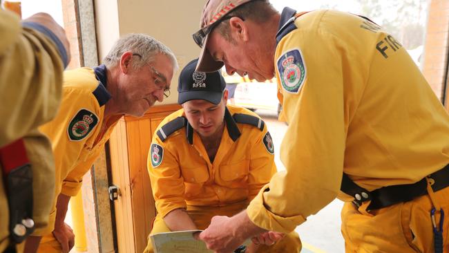 RFS members on standby at The Oaks RFS waiting to respond to spot fires in the area as bushfire burns in an inaccessible are. Picture: Richard Dobson