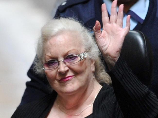 Judy Moran waves as she is lead into a prison van after being found guilty of murdering her brother-in-law Des 