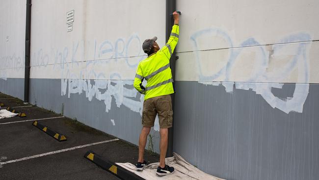 A council worker removes anti-Semitic graffiti from the wall of the carpark at the Mount Sinai College in Maroubra. Picture: Gaye Gerard