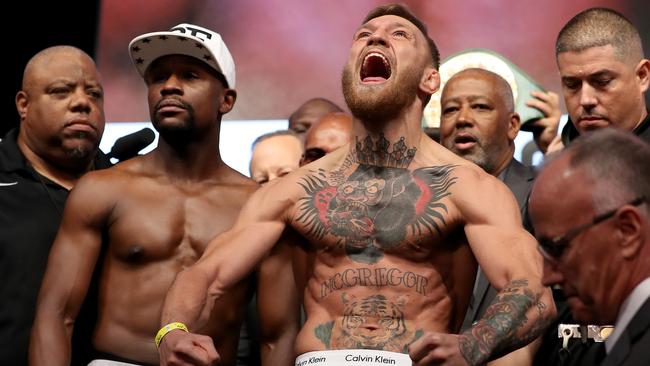 Conor McGregor (R) screams after the face off with Floyd Mayweather Jr.