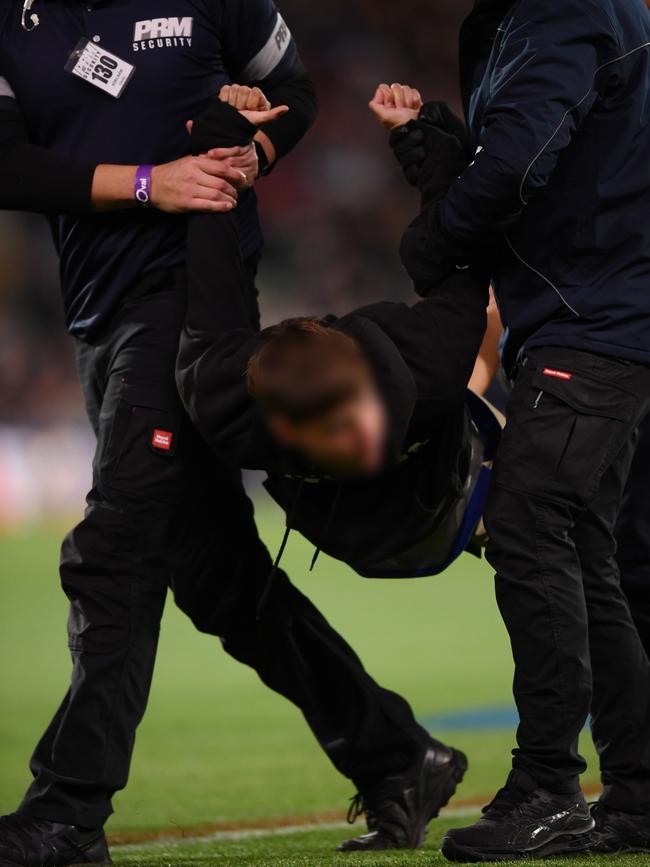 A pitch invader is carried off Adelaide Oval by security during the round three Showdown between Port Adelaide. Picture: Mark Brake / Getty Images