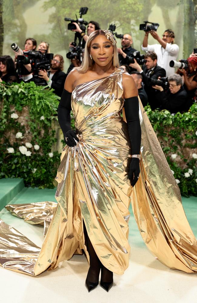 Serena Williams draped in black and gold on the red carpet.