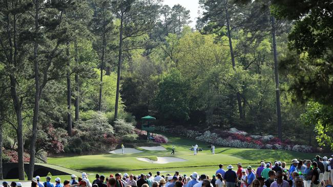 Tiger Woods, Tommy Fleetwood and Marc Leishman play the 12th green during the  2018 Masters at Augusta National Golf Club