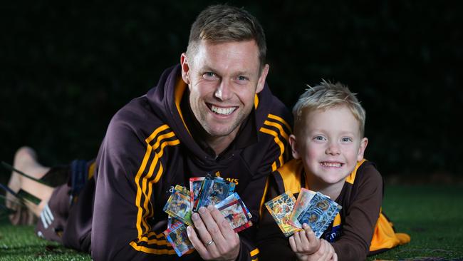 Hawthorn player Sam Mitchell and his son Smith, 6, with a selection of Footy Powers game cards. Picture: REBECCA MICHAEL