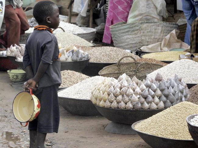 Boy looking at corn, rice and millet at food market in Maradi, Niger, Africa 09 Jul 2005. poor poverty child