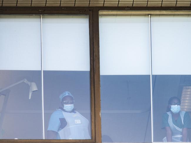 Health workers look out of a top floor window at the St Thomas' Hospital. Picture: Getty