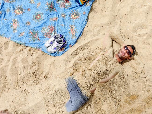 Weather Pic. St Kilda Beach. Josh, 30 is buried in the sand. Picture Tim Carrafa