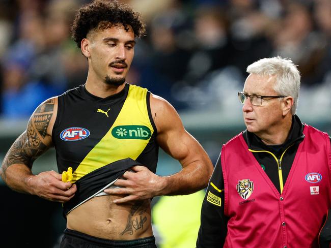 MELBOURNE, AUSTRALIA – JUNE 01: Mykelti Lefau of the Tigers heads to the change rooms with medical staff during the 2024 AFL Round 12 match between the Geelong Cats and the Richmond Tigers at GMHBA Stadium on June 01, 2024 in Melbourne, Australia. (Photo by Dylan Burns/AFL Photos via Getty Images)