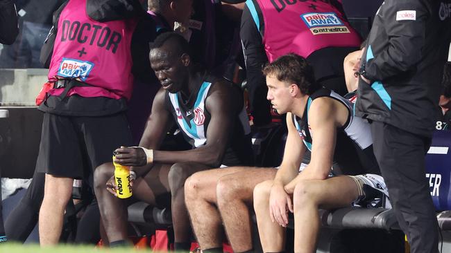 Aliir Aliir sits on the bench after a collision with Lachie Jones. Picture: Getty Images