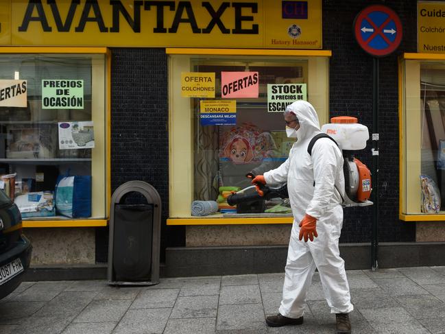 A man dressed in protective gear carries out disinfection works in a street in Vigo, northwestern Spain. Picture: AFP