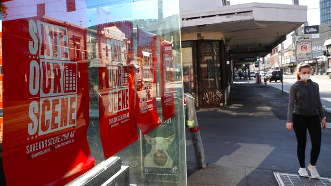 A bar displays Save Our Scene signs in their window on Swan Street in Richmond. Picture: David Crosling