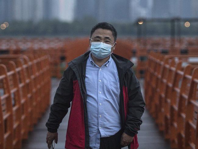 WUHAN, CHINA - MARCH 26: (CHINA OUTA resident wearing a protective mask walks in Jiangtan park after its re-opening on March 26, 2020 in Wuhan, Hubei province, China. With the permission of the local government, the park will reopen gradually. Local media have reported that authorities could lift the lockdown in early April. (Photo by Getty Images)