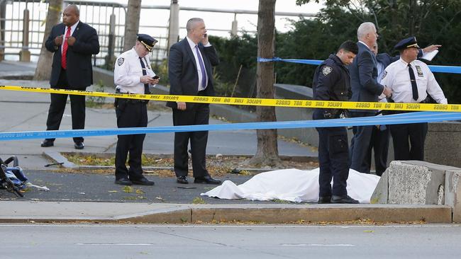 Police officers stand near one of the victims. Picture: AP