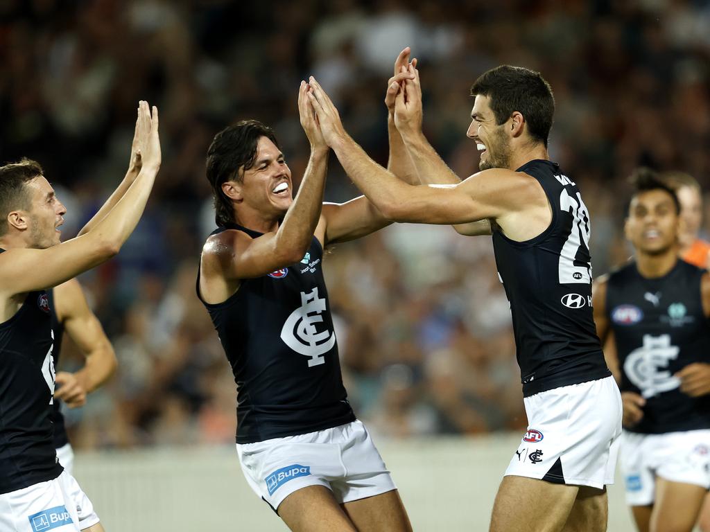 George Hewett celebrates a Carlton goal with Elijah Hollands and Orazio Fantasia.