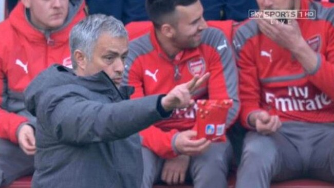 Two men are spotted passing around Maltesers on the Arsenal bench.