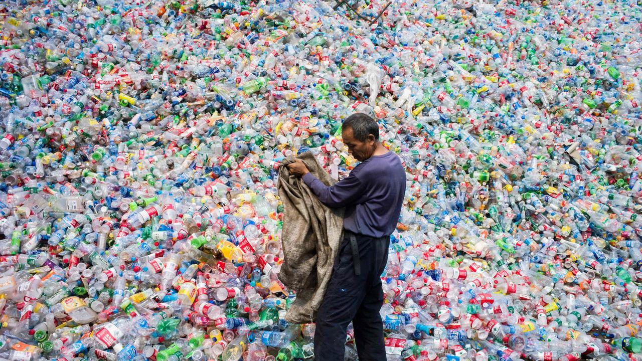 A Chinese labourer sorting out plastic bottles for recycling in Dong Xiao Kou village, on the outskirts of Beijing. Picture: Fred Dufour/AFP