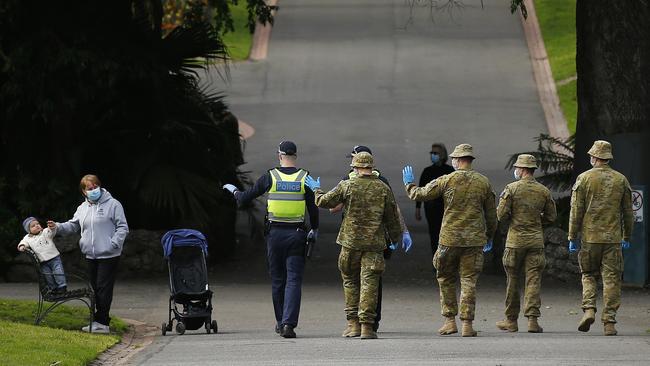 Police and military personnel patrol in Fitzroy Gardens in Melbourne on Monday. Picture: Daniel Pockett