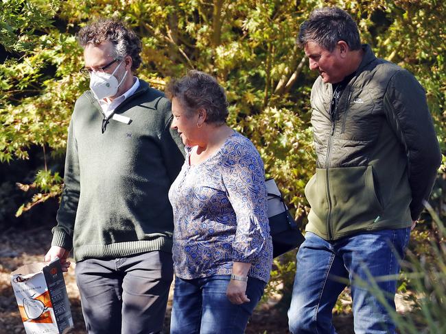 A Newmarch Hose staff member wearing a face mask walks family members into the facility on Saturday. Picture: Sam Ruttyn