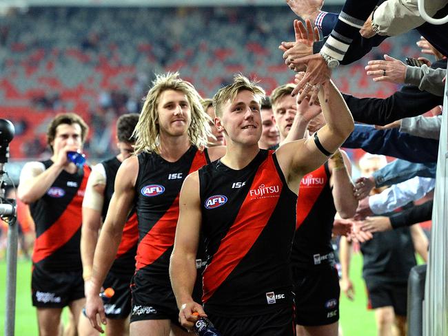 Essendon players celebrate with fans after the match. Picture: Getty Images